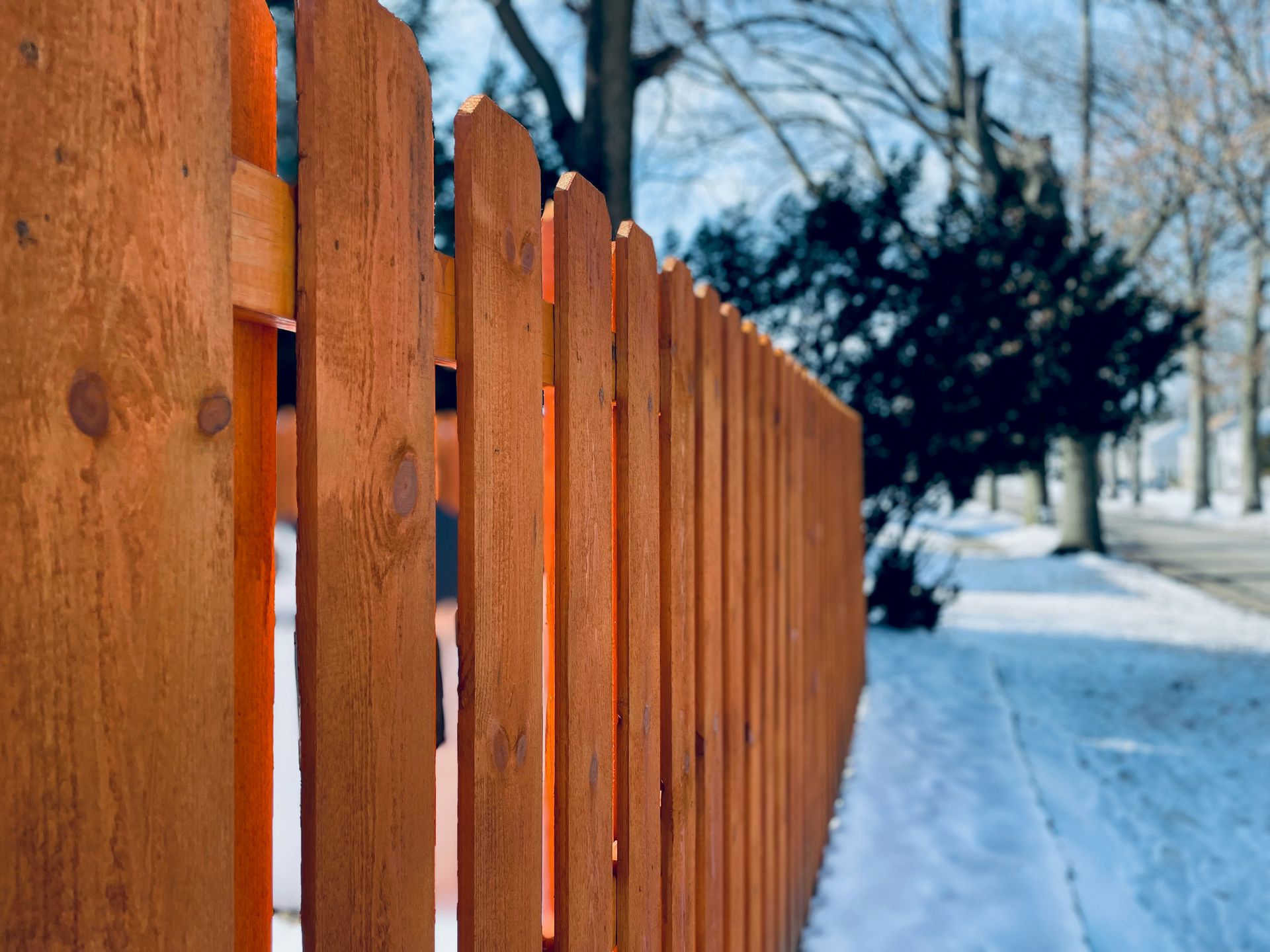 a close up of a wooden fence in the snow